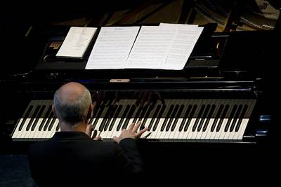 una vista del pianista, el teclado del instrumento y las partituras vistos desde arriba