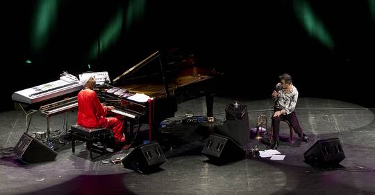 imagen general del escenario del teatro cervantes con omar sosa tocando el piano a la izquierda de la foto mientras paolo fresu canta a la derecha