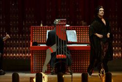 una escena de un actor vestido de seporita y un pianista acompañándole